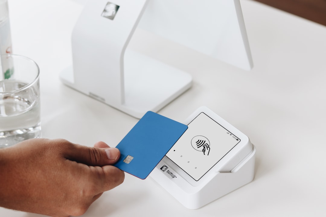 A close-up of a customer making a contactless payment with a blue card using the SumUp Solo card reader. In the background, a larger point of sale (POS) system is visible, emphasizing the versatility and modern design of SumUps payment solutions. The scene reflects a sleek and efficient checkout process ideal for small businesses, beauty salons, cafes, or retail environments.